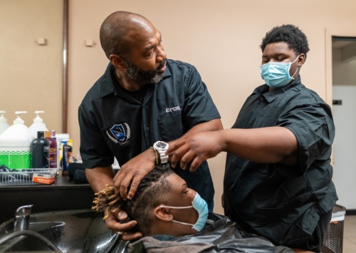Spring ISD's first barbering academy opened Nov. 9 at Westfield High School. The program is a partnership between SISD and local barber Eros Shaw (left) who teaches students in grades 9-12, such as Mathias Smith (right) and Shemar Porch (center). (Courtesy Spring ISD)