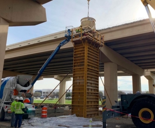 Construction crews working on column that holds road above it.