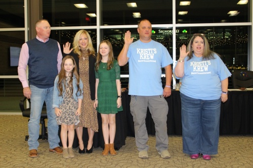 The New Caney ISD board of trustees at a Nov. 15 meeting canvassed the results of the Nov. 2 election. From left, Jarred Tompkins, Emma Tompkins, Position 4 trustee Angela Tompkins, Ava Tompkins, Position 5 trustee Chad Turner and Position 3 trustee Wendy Sharp stand in front of the dais as Tompkins, Turner and Sharp are sworn in to the board of trustees. (Wesley Gardner/Community Impact Newspaper)