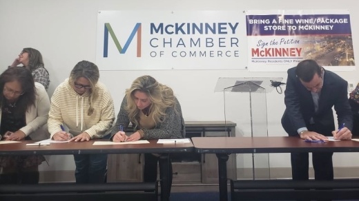 people signing petition at table