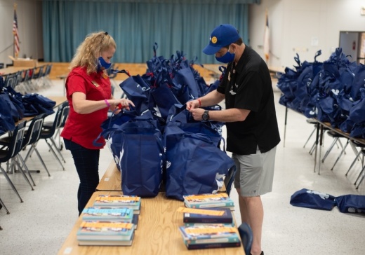 two rotary members filling bags with books