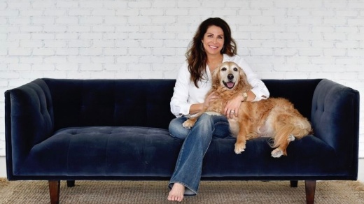 Heather Denton sitting on couch with her dog