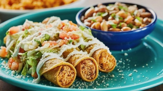 The Tacos Dorados ($14) are made with pulled chicken and are topped with salsa verde, lettuce, sour cream, pico de gallo and cotija cheese. (Courtesy Blue Goose Cantina)