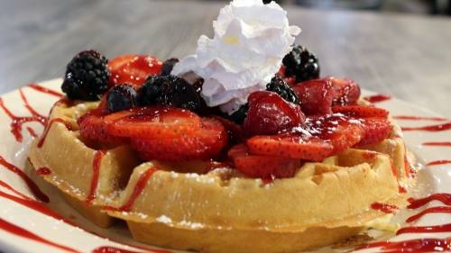The Very Berry Waffle ($9.95) is topped with fresh blueberries, strawberries, blackberries and raspberries along with powdered sugar, whipped butter and warm syrup. (Karen Chaney/Community Impact Newspaper)