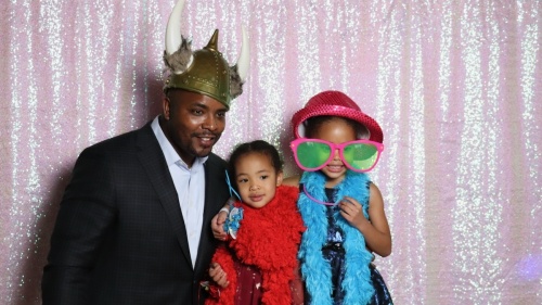 father and two daughters with photo booth props