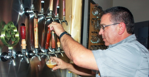 Co-owner Cody Evans pours a glass of Lite Brite, one of the 18 beers brewed and sold at DECA Beer Co. in Porter.(Wesley Gardner/Community Impact Newspaper)