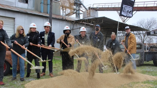 McKinney Community Development Corp. and Keith Lewis toss beer grains with shovels