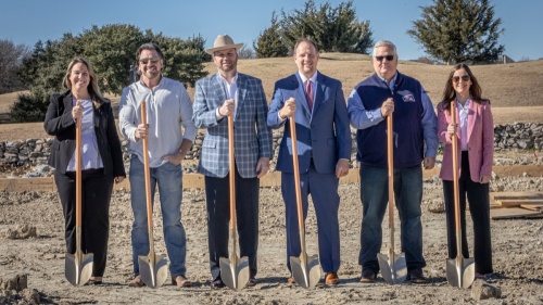 six people posing with shovels