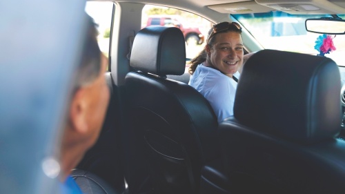 volunteer driver smiling at back seat passenger