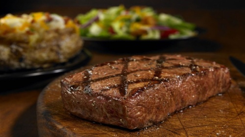 Outback Steakhouse steak with salad and baked potato