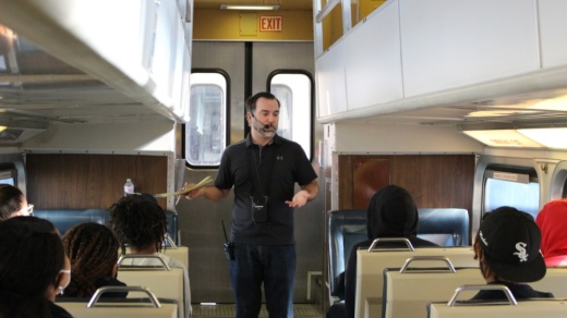 John Garbutt speaking in train aisle