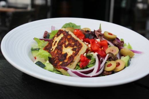 The Greek ($15) includes chopped romaine, feta, kalamata olives, green olives, roasted red peppers, cucumbers and red onion tossed in a light Greek dressing with grilled halloumi. (Karen Chaney/Community Impact Newspaper)