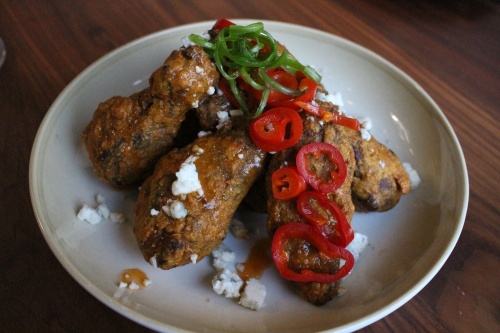The hickory smoked wings ($15) are made with a house hot sauce and pickled peppers with blue cheese. 