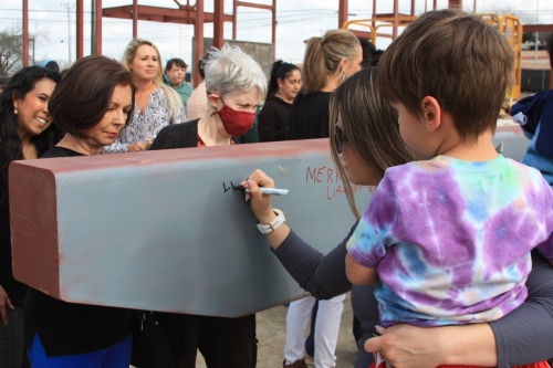 Residents sign a beam at the Feb. 16 topping out ceremony for the Westside Branch of the New Braunfels Public Library. (Lauren Canterberry/Community Impact Newspaper)