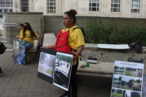 Protestor Veronica Medina held posters to show the impacts of floodwaters in her community. (Sofia Gonzalez/Community Impact Newspaper)
