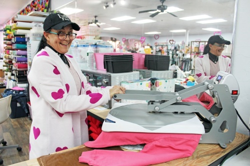 Customer service representative Tammy Mikalauskas completes a custom vinyl shirt order. (Photos by Karen Chaney/Community Impact Newspaper)