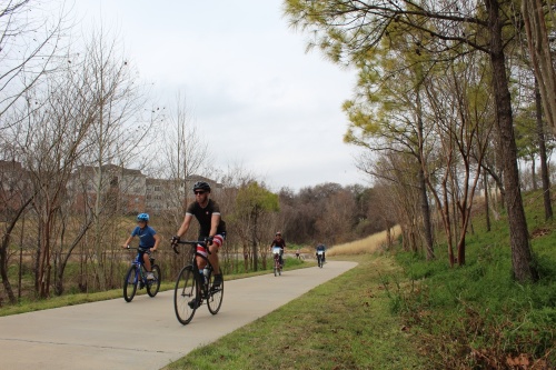 Cyclists ride along a bike trail near White Oak Bayou in the Heights. (Shawn Arrajj/Community Impact Newspaper)