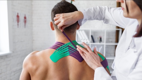  Physical therapist applying kinesiology tape to patient
