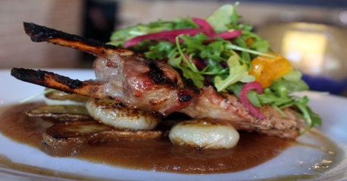 The pork chop ($28) includes apple sauce, cippolini onions, fingerling potatoes and arugula. (Karen Chaney/Community Impact Newspaper)