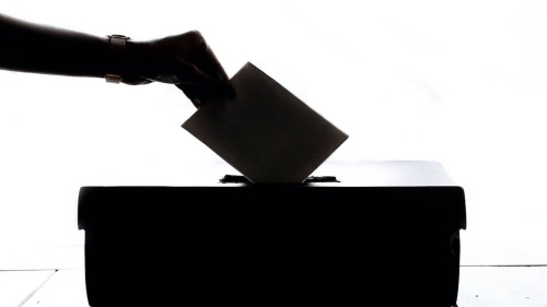 Voter dropping ballot into box