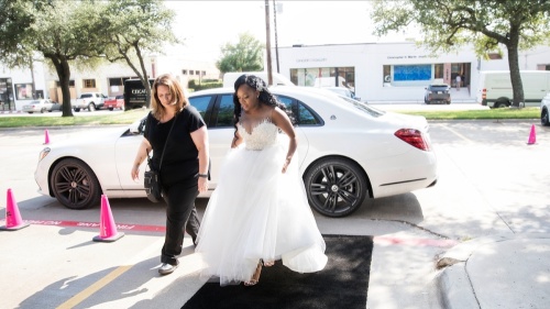 Wendy Kidd and bride walk down carpeted sidewalk