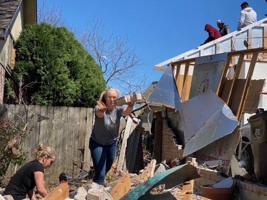 Lindsey Topolski, right, and her neighbor worked to clear debris from her home damaged by the March 21 tornado in Round Rock. (Brooke Sjoberg/Community Impact Newspaper)
