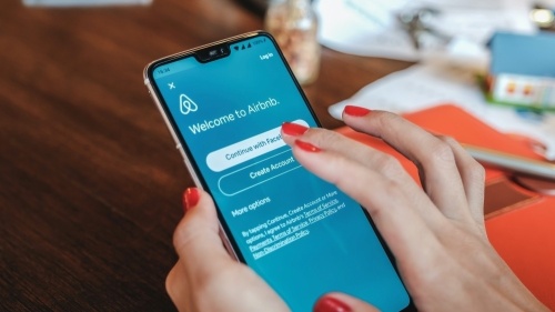 Photo of a hand scrolling through the Airbnb app