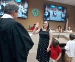 Hollywood Park Municipal Judge Darrell Dullnig administers the oath of office at City Hall on May 17 to Wendy Gonzalez, the new Hollywood Park Place 4 City Council member. Gonzalez is joined by her sons Waylon (left) and Cooper. (Edmond Ortiz/Community Impact Newspaper)