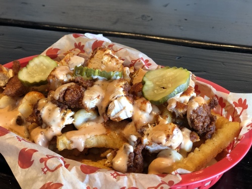 Urban Fries ($12) popularity is Owner Brandon Gawthorp's inspiration for the Chronic Fries virtual kitchen. The loaded fries basket is adorned with mac and cheese, chopped hot chicken tenders, bird sauce and pickles. (Asia Armour/ Community Impact Newspaper)