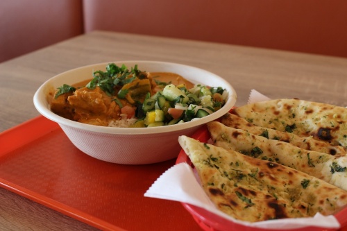 Indian Kitchen’s chicken tikka bowl ($12.99) and garlic naan ($3.25) are popular items. (Brooklynn Cooper/Community Impact Newspaper)