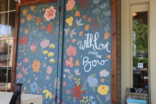 Painted on the side of one of downtown Murfreesboro's locally owned businesses, “With Love from the ‘Boro”  this floral scape encourages visitors to snap a photo before browsing for home decor and gifts. (Alana Thomas/Community Impact Newspaper)