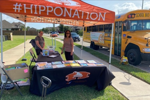 Photo of volunteers at a booth next to the reading bus