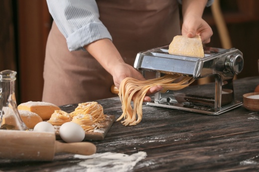 Closeup of person preparing pasta in kitchen