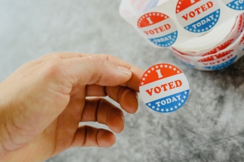 Hand holding "I voted" sticker
