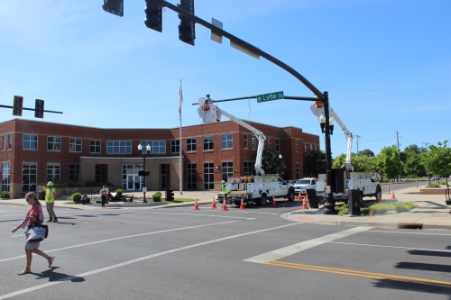 Contractors install new signals at the corner of West Lytle Street with North Maple Street on June 20.  The new signals will include a flashing yellow lights to indicate left turns are permitted after yielding to oncoming traffic and pedestrians. (Martin Cassidy/Community Impact Newspaper)