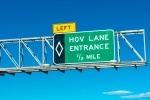 HOV lane entrance road sign. Blue sky.