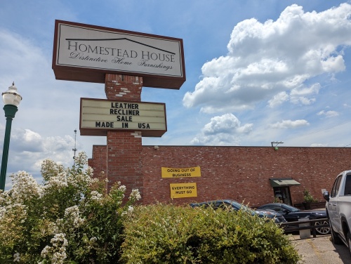 Homestead House sign in Conroe, a going out of business sign nearby