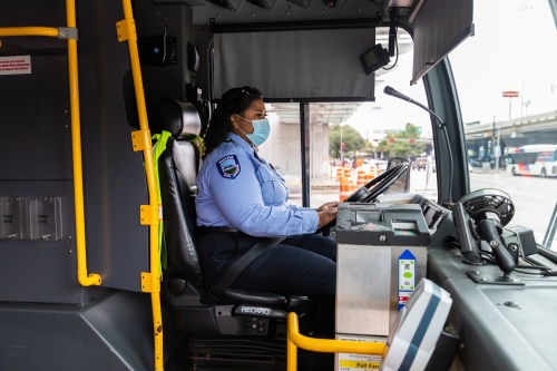 A bus driver sits at the wheel of a METRO bus. 
