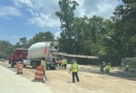 A road crew supervises a concrete mixer on Gosling Road.