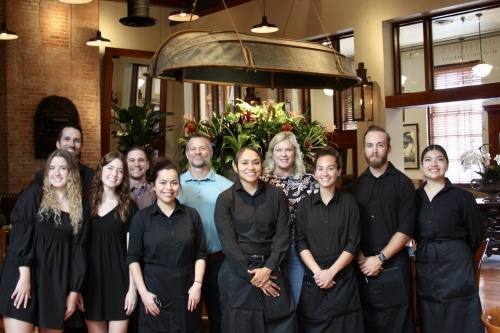 Becky Wiggins (fourth from right) and Scott Rouhselang (sixth from left) work with their staff at McAdoo's. (Lauren Canterberry/Community Impact Newspaper)