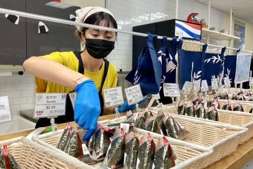 Asahi Imports employee Linda Taing makes fresh onigiri at the Onigiri Corner. (Chloe Young/Community Impact Newspaper)
