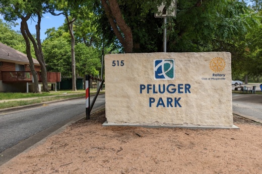 Photo of a sign reading "Pfluger Park" at an entrance to Pfluger Park