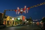 a string of lights with two reindeer hangs across a street 