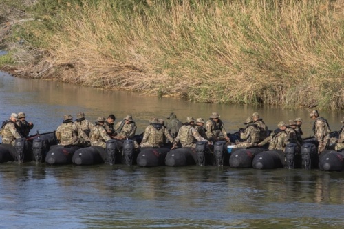 Military members work in the river as part of Operation Lone Star.