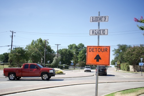 a sign reading "detour" in front of a roundabout