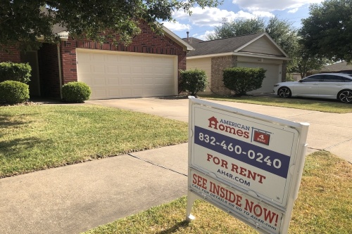 This is a picture of a home in Katy with a for rent sign by an investment firm in front.