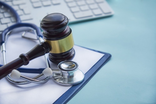 An image of a gavel and a stethoscope on a mousepad. 