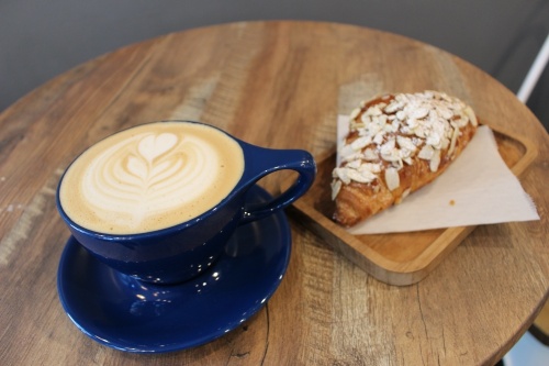 A Spanish latte ($4.95) and an almond croissant ($2.75) make for a quick meal at Renew Coffee N Bakery. (Miranda Jaimes/Community Impact Newspaper)