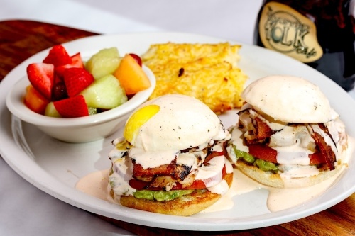 Among the dishes at The Toasted Yolk Cafe is the West Coast Arnold, which has two English muffin halves toped with Cajun turkey, bacon, tomato, guacamole and two poached eggs and is topped with Cholula ranch. (Courtesy The Toasted Yolk Cafe)