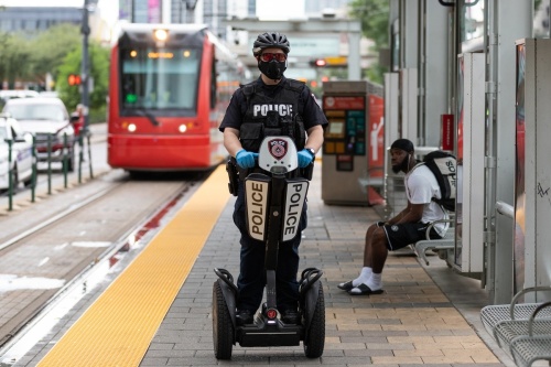A police officer rides parallel to light rail tracks on a segway 